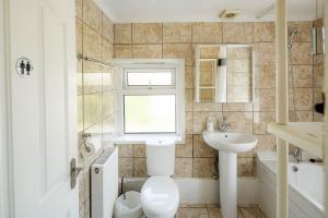a bathroom with a toilet and a sink at Swingate Lane Stay in Plumstead +15 photos