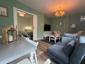a living room with a blue couch and a room with a bed at La Puerta del Valle in Villafranca del Bierzo