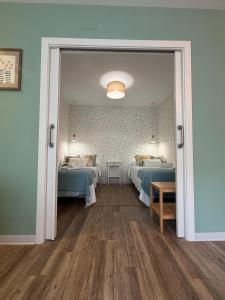 a room with two beds and a door open at La Puerta del Valle in Villafranca del Bierzo