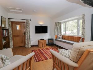 a living room with a couch and a window at Woodloft Cottage in Elterwater