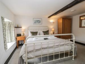 a bedroom with a white bed in a room at Woodloft Cottage in Elterwater