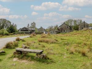a bench sitting in the grass next to a road at Woodloft Cottage in Elterwater
