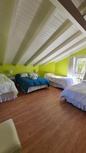a room with three beds in the middle of it at Cabañas Amalar in Malargüe