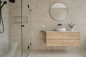 a bathroom with a shower with a sink and a mirror at Stylish & New 2 Bed & 2 Bath Apartment in Bathurst
