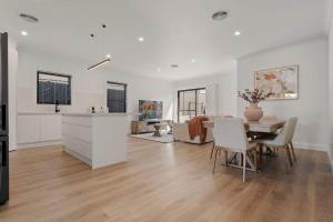 a kitchen and living room with a table and chairs at Stylish & New 2 Bed & 2 Bath Apartment in Bathurst