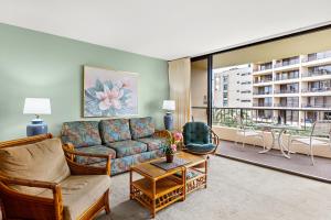 a living room with a couch and a balcony at Sugar Beach 304 in Kihei