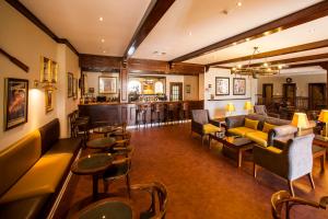 a hotel lobby with couches and tables and a bar at Vila Gale Ericeira in Ericeira