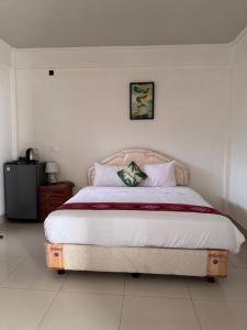 ein Schlafzimmer mit einem großen Bett mit weißer Bettwäsche in der Unterkunft Leokase Hotel in Dili