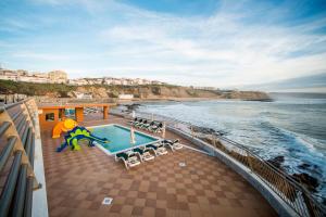 a balcony of a cruise ship with a pool and the ocean at Vila Gale Ericeira in Ericeira