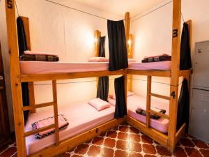 a room with three bunk beds in it at Amura Hostel - Antigua Guatemala in Antigua Guatemala +22 photos