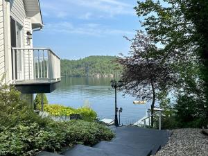 a house with a balcony and a view of a lake at Lakehouse Paradise in Val des Monts