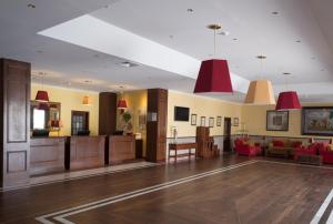 a lobby with red pendant lights and a living room at Vila Gale Ericeira in Ericeira