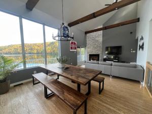 a living room with a wooden table and a couch at Lakehouse Paradise in Val des Monts