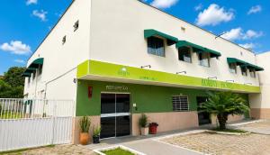a building with a green and white facade at BURITI HOTEL Barra do Riacho Aracruz in Aracruz