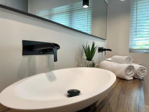 a white bath tub in a bathroom with a sink at Lakehouse Paradise in Val des Monts +62 photos