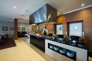 a man standing in a kitchen with a counter at Vila Gale Ericeira in Ericeira