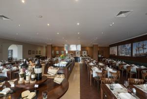 a restaurant with tables and chairs and wine glasses at Vila Gale Ericeira in Ericeira