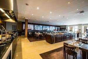 a restaurant with a buffet line with tables and chairs at Vila Gale Ericeira in Ericeira