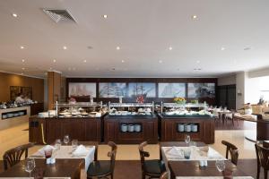 a restaurant with tables and chairs and a buffet at Vila Gale Ericeira in Ericeira