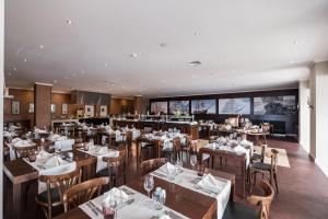 a restaurant with tables and chairs and a bar at Vila Gale Ericeira in Ericeira