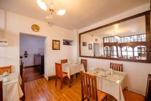 a dining room with two tables and a mirror at Yabar Hotel Plaza in Cusco