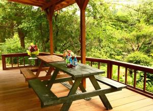 a picnic table on the deck of a porch at Pocheon Haneulbat Pension in Pocheon