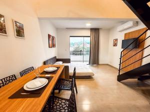 a dining room with a table and chairs and a living room at Centro: Flat p/ 4 pessoas + Vaga in Brusque