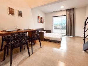 a living room with a table and chairs and a bed at Centro: Flat p/ 4 pessoas + Vaga in Brusque