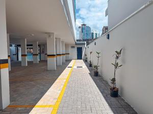an empty hallway of an office building with plants at Centro: Flat p/ 4 pessoas + Vaga in Brusque