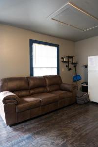 a brown leather couch in a room with a window at "Rustic Getaway A Charming & Cozy Cottage for Two or Four!" in Geneva