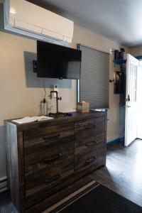 a large wooden dresser with a television on top of it at "Rustic Getaway A Charming & Cozy Cottage for Two or Four!" in Geneva +35 photos