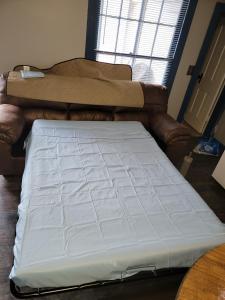 a bed sitting in a room with a couch at "Rustic Getaway A Charming & Cozy Cottage for Two or Four!" in Geneva