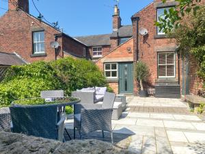a patio with chairs and a table in front of a building at 3 Bed in Belper oc-o28261 in Belper