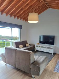 a living room with a couch and a television at Casa do Galante in Nordeste