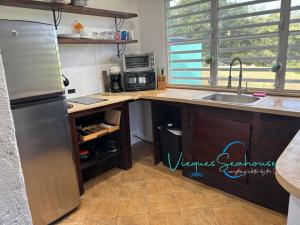 a kitchen with a stainless steel refrigerator and a sink at Cozy chill island roundhouse magic 2 miles from beach-The Vieques Seahouse in Moscou