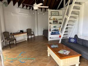 a living room with a couch and a staircase at Cozy chill island roundhouse magic 2 miles from beach-The Vieques Seahouse in Moscou