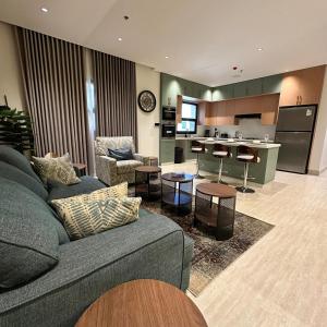 a living room with a couch and a kitchen at مساكن المها - شقق وأستديوهات - بتأثيث متكامل ومريح in Al Khobar