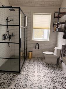 a bathroom with a shower and a toilet and a window at Auberge McGowan in Austin