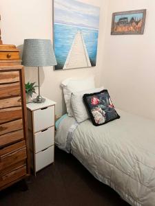 a bedroom with a bed with a pillow on it at Oceanside to Seaside 334 in Mount Maunganui +7 photos