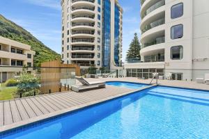 a swimming pool in front of two apartment buildings at Oceanside to Seaside 334 in Mount Maunganui