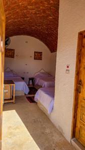 a bedroom with three beds in a room at Agmair Amellal in Siwa