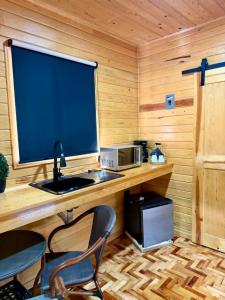 a kitchen with a desk with a microwave and a television at Caminante in Creel