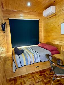 a small bedroom with a bed in a wooden cabin at Caminante in Creel