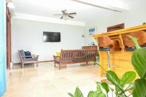 a living room with a bench and a flat screen tv at Hidden Secret in Gros Islet