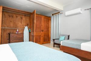 a bedroom with two beds and a chair in it at Hidden Secret in Gros Islet