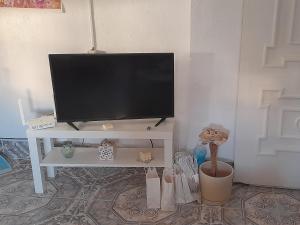 a flat screen tv sitting on top of a white table at A Beautiful Townhouse with a roof top terrace in Rute