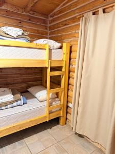a bedroom with two bunk beds in a log cabin at Cabaña Manzano Historico Punta Negra Lodge 1 in Tunuyán