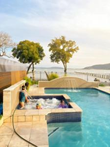 a family playing in a jacuzzi in a swimming pool at Bluewater sanctuary in Point Clare
