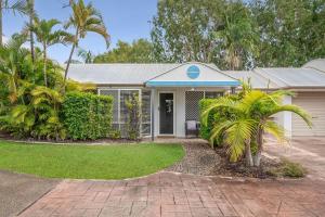 a house with palm trees in front of it at Renovated 2 Bedroom Ground Level Villa in Noosaville in Noosaville