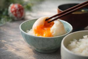 a bowl of rice with an egg on top with chopsticks at The Celecton Fukushima in Fukushima